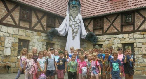 Wyjazd dzieci podczas akcji wakacyjnej do Magicznej Pławnej. Na zdjęciu grupa dzieci w tle postać ducha g&oacute;r.