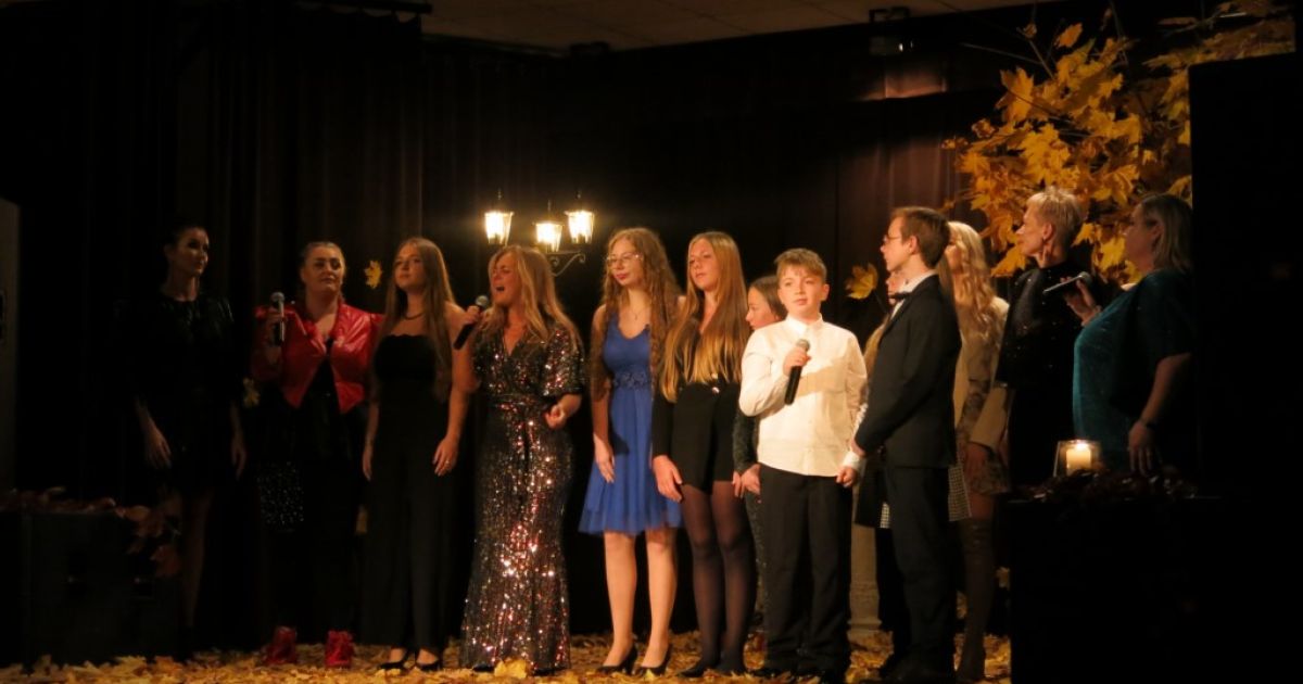 Wszyscy wykonawcy na scenie śpiewający na zakończenie wsp&oacute;lną piosenkę.